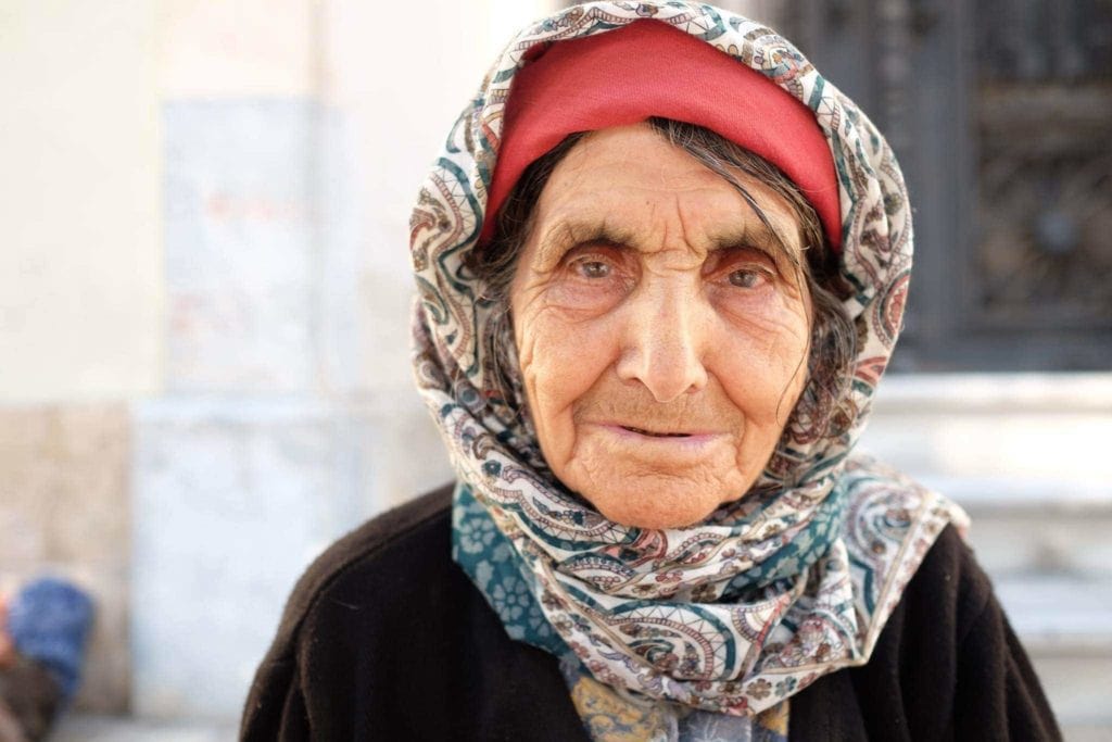 An elderly woman selling flowers in Antalya.